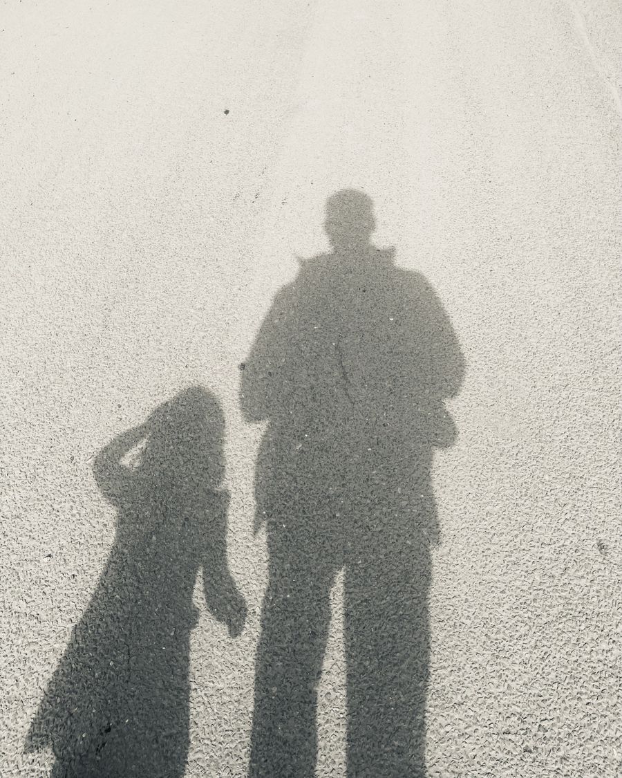 Adam's shadow on a sunny path, beside a child's