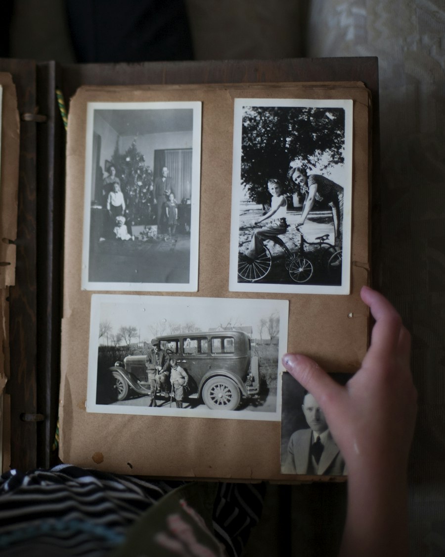 Hands opening an old album of black and white family photos